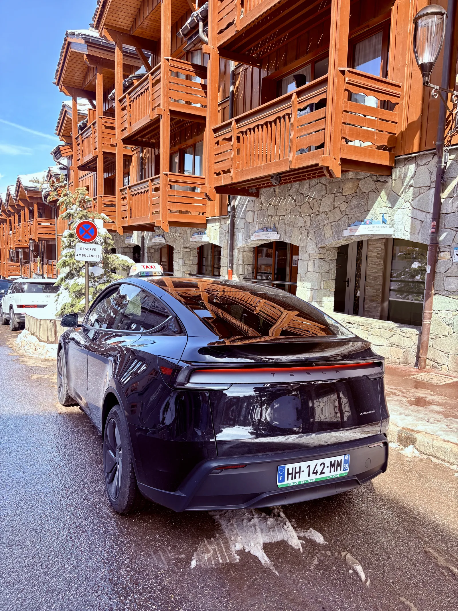 Tesla premium devant une gare pour transfert taxi vers Lyon Saint-Exupéry